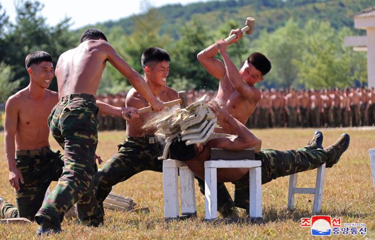 Soldiers of North Korea's special operations forces break layers of bricks placed over the face of a comrade during North Korean leader Kim Jong-un's visit to the unit on Oct. 2. Yonhap 