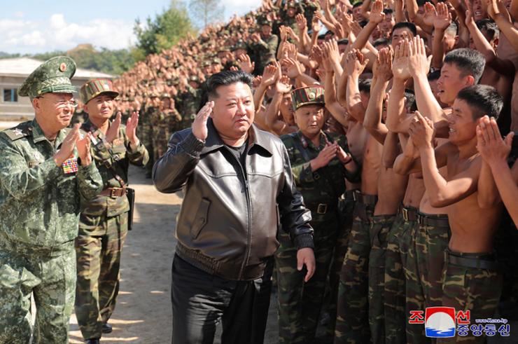 North Korean leader Kim Jong-un, center, salutes as he walks past cheering special forces soldiers during a visit on Oct. 2. It was Kim's second visit to North Korea's special operations forces since September. Yonhap  