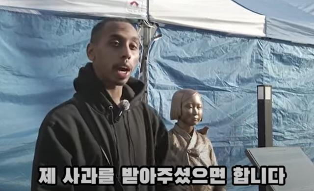 Johnny Somali, an American YouTuber, apologizes in a video on Thursday for kissing a statue symbolizing Korean victims of wartime sexual slavery. Captured from YouTube