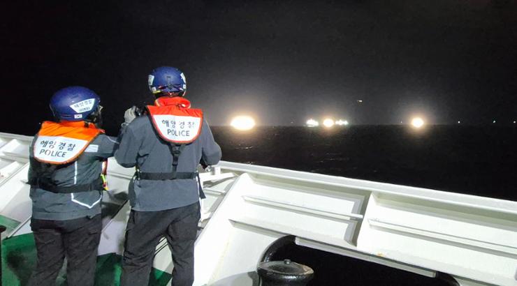 Coast guard officers undertake a search operation for missing crew members in waters off Jeju Island, Friday. Yonhap